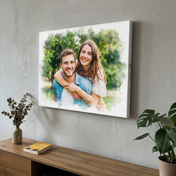 Canvas print of a couple in an artistic style hanging on a wall above a wooden surface with a plant and book.